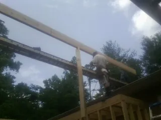 Carpenter setting a ridge beam over a new addition frame — Ice Dam Removal by Roofing Brothers in Weyauwega