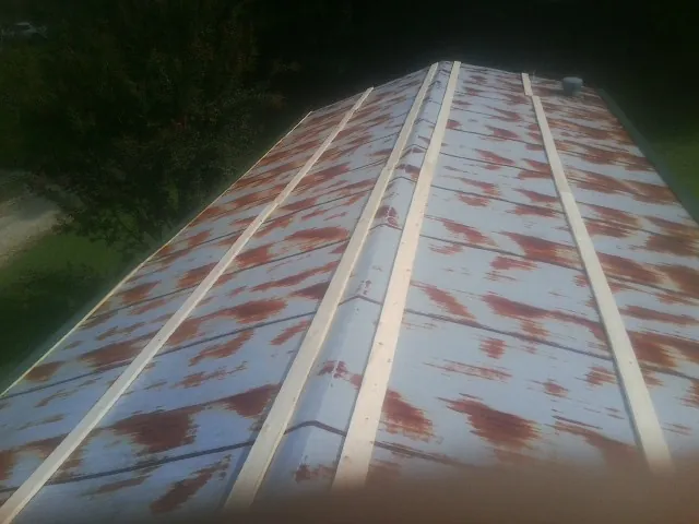 Rusted metal roof panels with new wood purlins before replacement — Storm Damage Roof Repair in Weyauwega by Roofing Brothers
