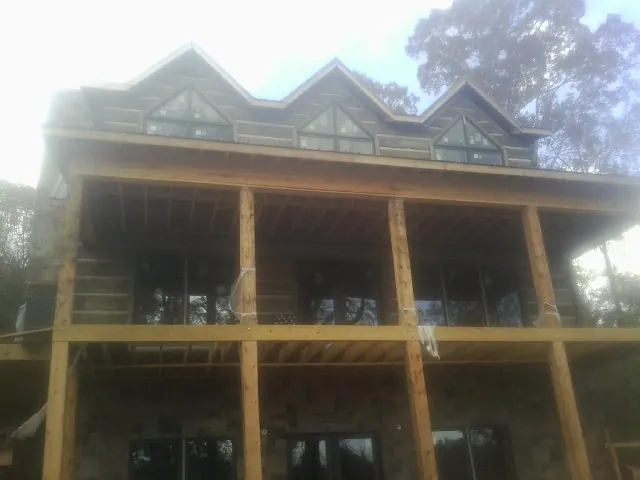 Dormers and porch framing on a large log home under construction — Roof Coating work by our crew in Weyauwega